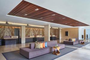 塞米亚克Courtyard by Marriott Bali Seminyak Resort的大堂设有两张紫色沙发和一张桌子