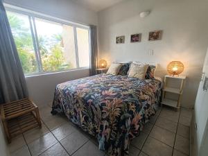拉罗汤加穆里度假公寓的一间卧室设有一张床和一个大窗户