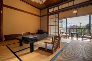 秦野市Jinya Ryokan的客房设有桌椅和阳台。