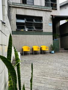 圣保罗Center Hostel Sp的一座带黄色椅子的庭院和一座建筑