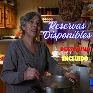 特木科Hostal Sol Temuco的站在厨房里搅拌锅的女人