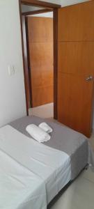 布卡拉曼加habitación con baño en bucaramanga-cerca sena-uis的一张带两条白色毛巾和木门的床