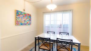 长滩Long Beach Cozy Remodled Home的一间带桌椅和绘画的用餐室
