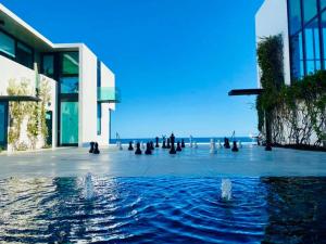 Boca de la Vinorama维达首尔酒店的一座在海洋前方设有喷泉的建筑