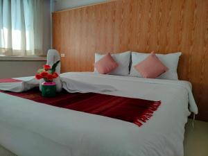 董里S2S皇后庄酒店的卧室配有带粉红色枕头的大型白色床