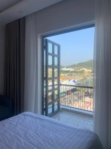 河仙Hà Hùng Panorama Hotel的一间卧室设有一张床,享有阳台的景色