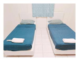 古晋Richmond Residence的配有两张床铺的蓝色床单和枕头