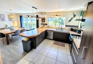 派西亚Unique Estuary & Bird Apartment in Te Haumi Paihia的厨房配有木制台面和桌子