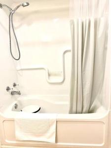 萨尼亚Bluewater Delight的带淋浴和盥洗盆的白色浴室