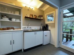 卢拉Burradoo Studio的厨房配有白色橱柜和水槽