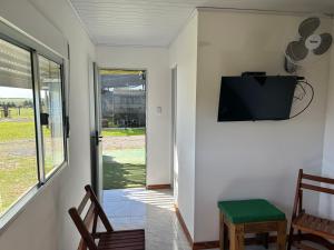 QuebrachoPosada campo bello的客房设有电视、椅子和窗户。