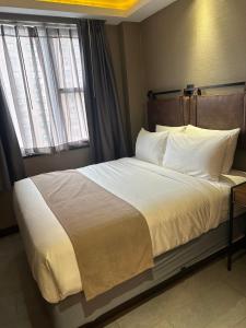 纽约麦迪逊LES酒店的一间卧室配有一张带白色床单的床和一扇窗户。