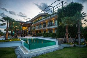 Bang HiaThe River Palm Resort的一座建筑前面设有游泳池