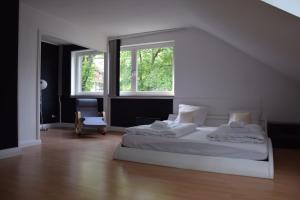 柏林迪尔曼斯之家旅馆的一间白色卧室,配有床和2个窗户
