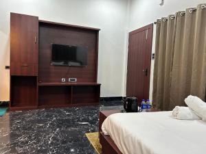 FālākātaAAHI'S CHILAPATA JUNGLE STAY的配有一张床和一台平面电视的酒店客房
