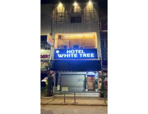 钱德加尔Hotel White Tree, Chandigarh的建筑一侧的酒店白树标志