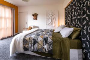 LuggateThe Artist's House Wanaka的一间卧室配有一张带被子和枕头的床