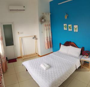 惹岛Ly Tri Ly Son Hotel的卧室配有白色床和蓝色墙壁