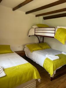 里奥班巴Steingarten, Casa de Campo hermosa y amoblada.的配有黄床单的客房内的两张双层床