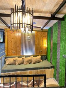 碧瑶Holyghost Veranda Baguio Transient Guest House 42 step rooftop的绿墙和吊灯的房间里长凳