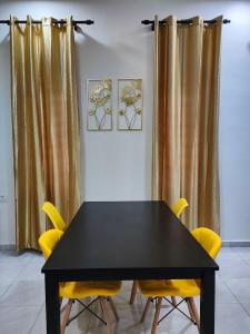 Kepala BatasHomestay HABI Residence的一张黑桌子和黄色椅子