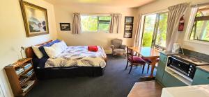 Upper Moutere水车度假屋的一间卧室配有一张床、一张桌子和一张桌子