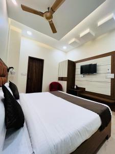 阿姆利则Monga Dream Residency - 5 MINUTES WALK FROM GOLDEN TEMPLE的一间卧室配有一张床和一台平面电视