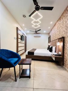 阿姆利则Monga Dream Residency - 5 MINUTES WALK FROM GOLDEN TEMPLE的一间卧室配有一张床和一张蓝色椅子