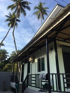 帕干岛World Citizen GuestHouse的一座房子,后面设有棕榈树门廊