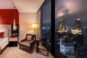科伦坡Mövenpick Hotel Colombo的配有一张床、一张书桌和一扇窗户的酒店客房