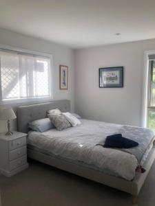 巴瑟斯特Danara Cottage的白色的卧室设有床和窗户