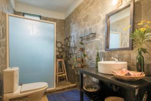 KinigiKinigi Cottage的一间带卫生间、水槽和镜子的浴室