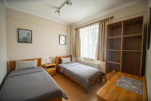 乌兰巴托扎亚旅馆的一间卧室设有两张床和窗户。