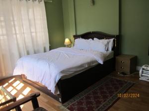 帕坦KAJI HOME的一间卧室配有一张带白色床单的大床