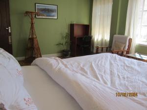 帕坦KAJI HOME的卧室配有带白色棉被的床