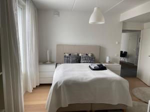 赫尔辛基Upea 117,5m2 huoneisto Helsingin keskustassa的一间白色卧室,配有床和2个床头柜