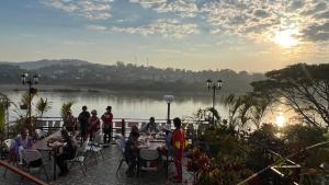清孔戴伊水滨酒店的一群人坐在河边的桌子旁