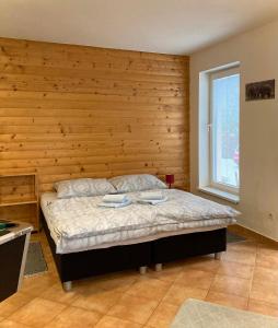 新里斯拉利萨纳旅馆的一间卧室配有一张木墙床