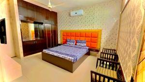 卡拉奇Pramier Inn Near Agha Khan Hospital的一间卧室配有一张带橙色床头板的床