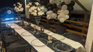 利伯维尔Namaste hotel & restaurant的一张长桌,上面有白色的桌布和气球