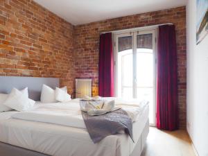 巴特Speicher Barth - Superior-Hotel的卧室配有一张白色大床和砖墙