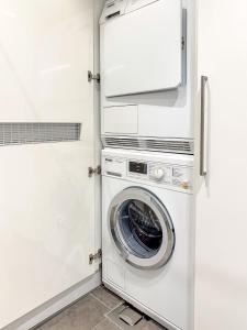 汉科Regatta Seaside Suite in Hanko的白色洗衣房内的洗衣机和烘干机