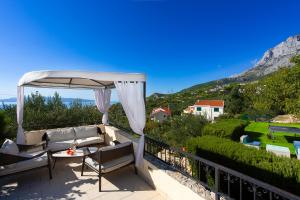 马卡尔斯卡Villa Filip Spa & Relax Makarska的一个带沙发和遮阳伞的庭院
