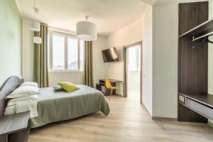 萨尔索马焦雷泰尔梅Salsomaggiore Golf Guest House的一间卧室配有一张床、一张书桌和一台电视