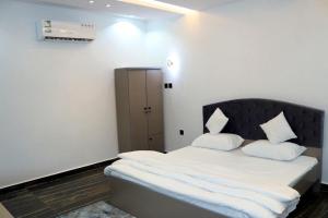 Sūq al Aḩadنيلوفر بيتي的一间卧室配有带白色床单和枕头的床。
