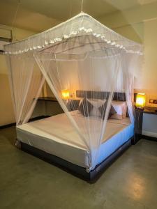 锡吉里亚Lankapura Heritage的客房内的一张带蚊帐的床