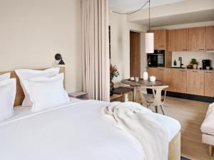 奥胡斯Aura Apartment Hotel的一间带白色床的卧室和一间厨房