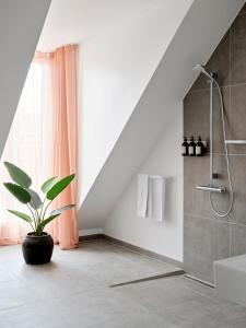 奥胡斯Aura Apartment Hotel的带淋浴和盆栽的浴室