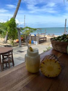 阿鲁甘湾Arugamabay Surf Resort的 ⁇ 萝酱在一篮子水果旁边的桌子上