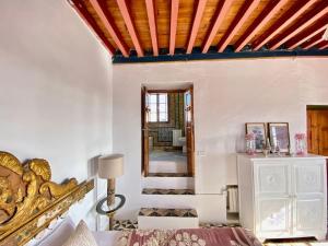 突尼斯Lella Khadija B&B Sidi bou said的客房设有一张床和带橙色横梁的天花板